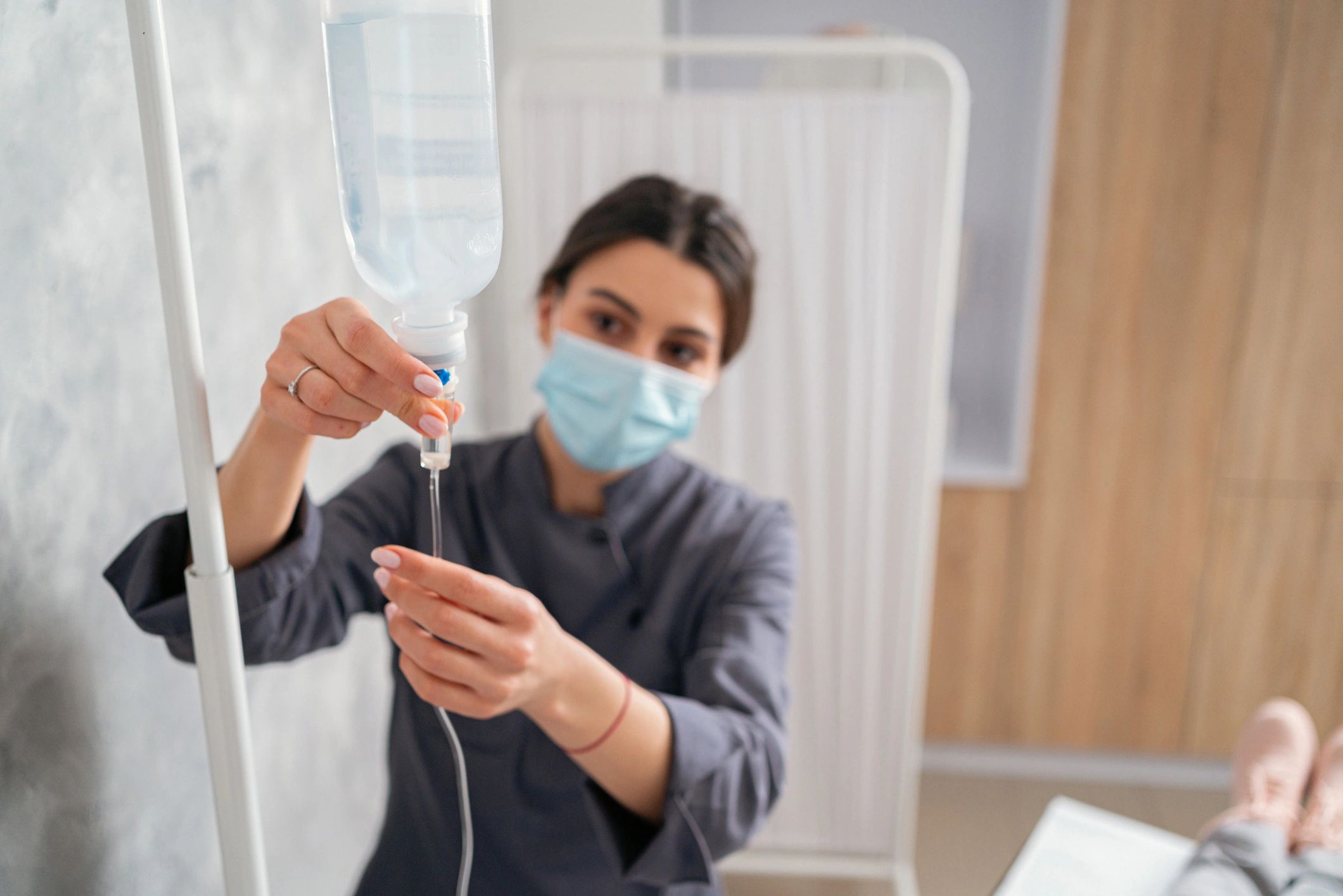 Nurse adjusting an IV drip in a clinic setting